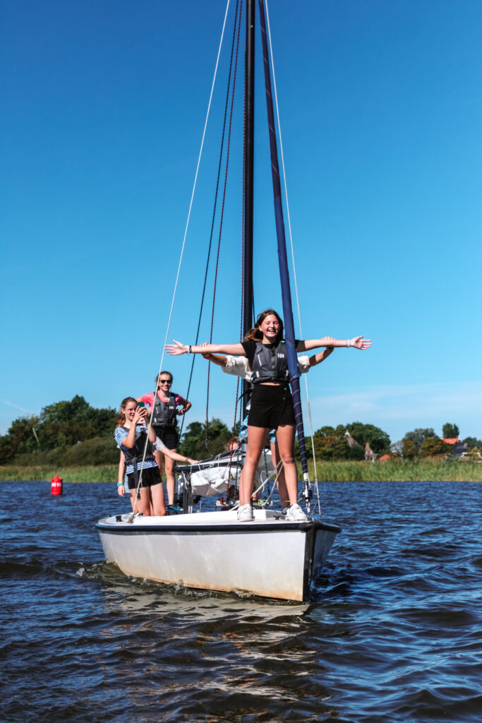 Leerlingen zeilen tijdens een actieve schoolreis op het water.