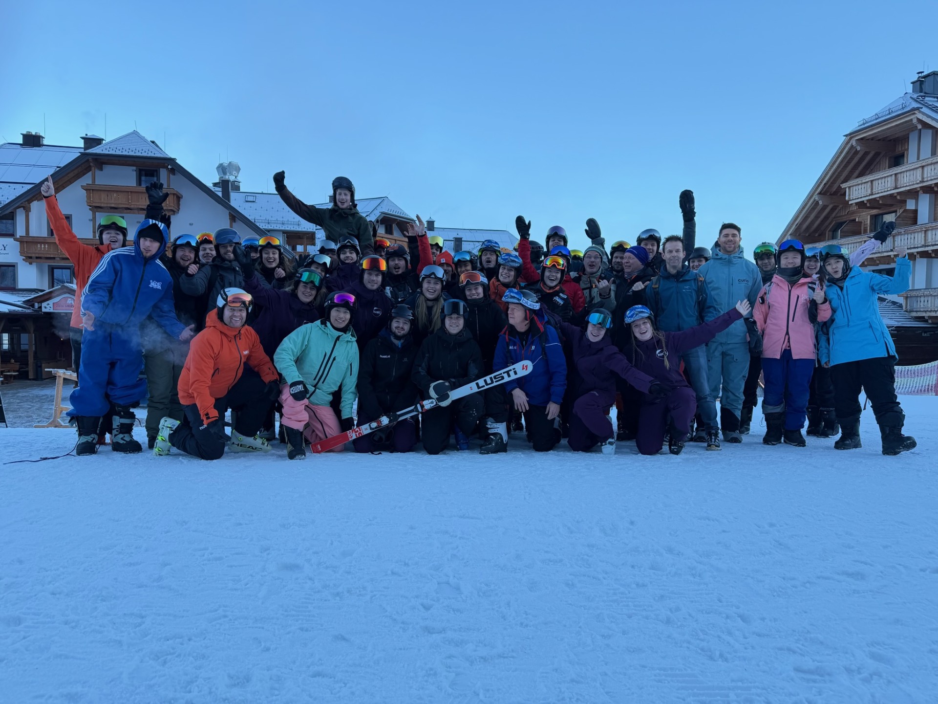 Grote groep wintersporters poseert in de sneeuw